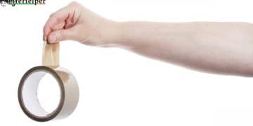 Hand holding roll of adhesive tape